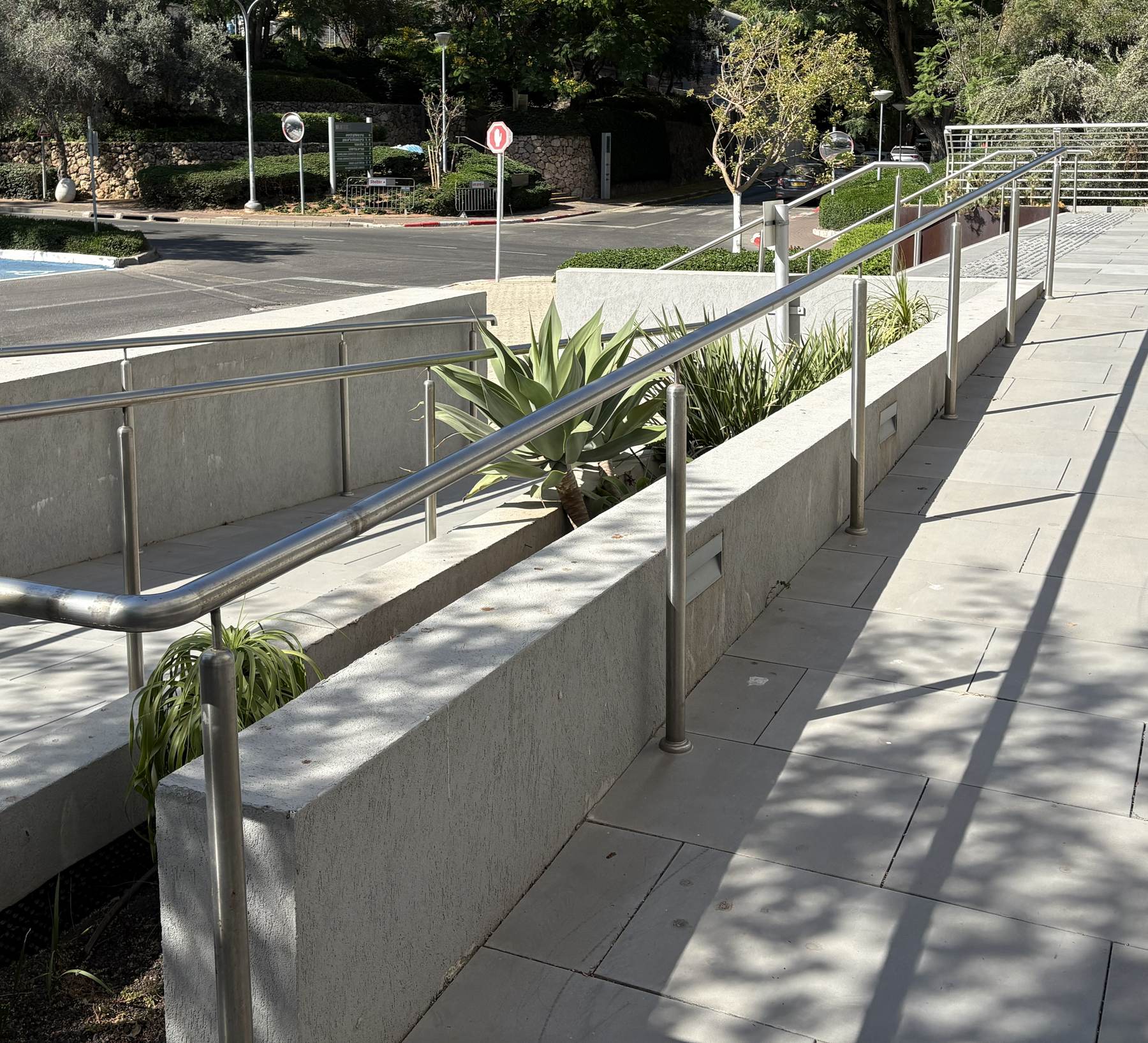 רמפה נגישה עם מעקה נירוסטה כפול, בדרך ממקומות החניה הנגישים אל הכניסה